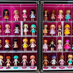 A vibrant and colorful LOL Surprise doll collection displayed in a transparent case, showcasing various dolls with different rarities (Common, Popular, Rare, Ultra-rare), alongside neatly organized accessories in a dedicated storage box.